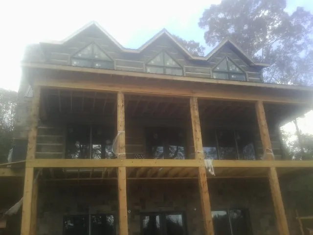 Dormers and porch framing on a large log home under construction — Roof Coating work by our crew in Renovo